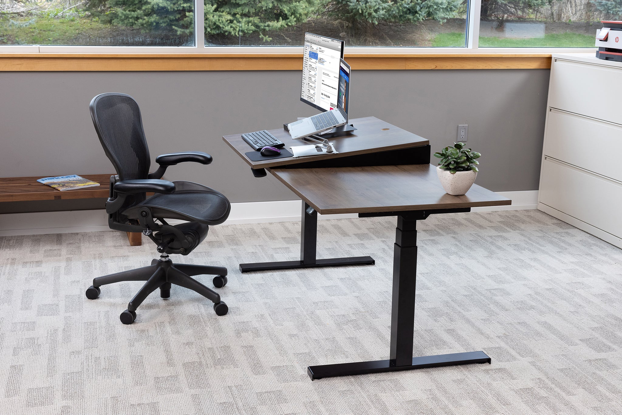 Teeter Sit-Stand Desk - Adjustable Height Ergonomic Workstation with Stool, Side Table, and Foot Platform.